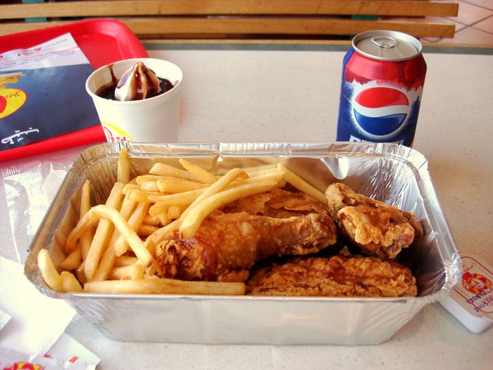 A broasted chicken meal with fries and bread
